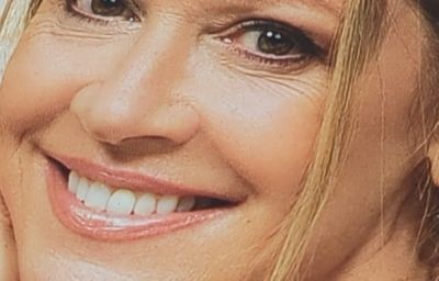 Film still from 'Ship of Fools' (2026) by Jon Beaton. A woman's smiling face in close up.